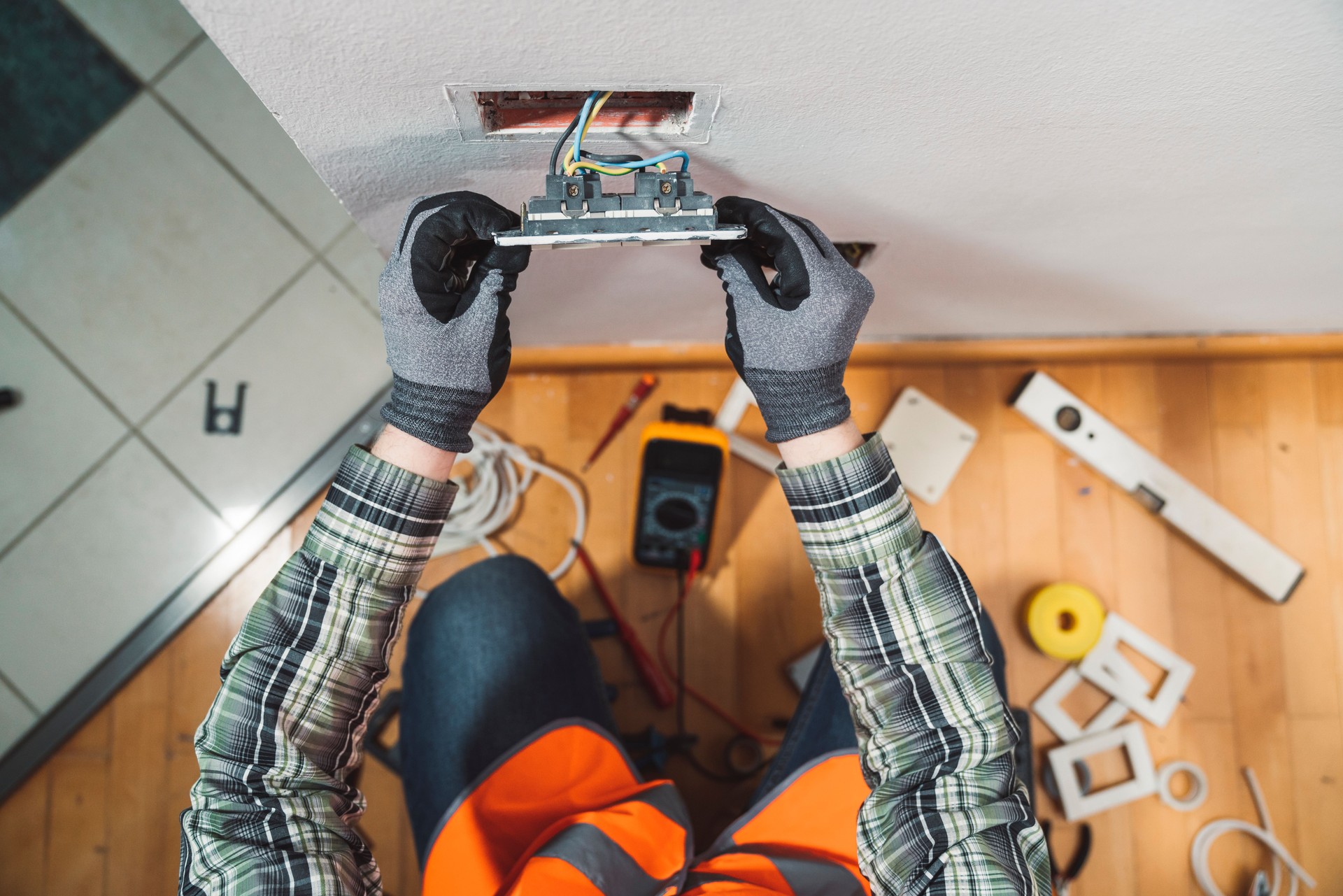 An electrician setting up plug sockets in a house