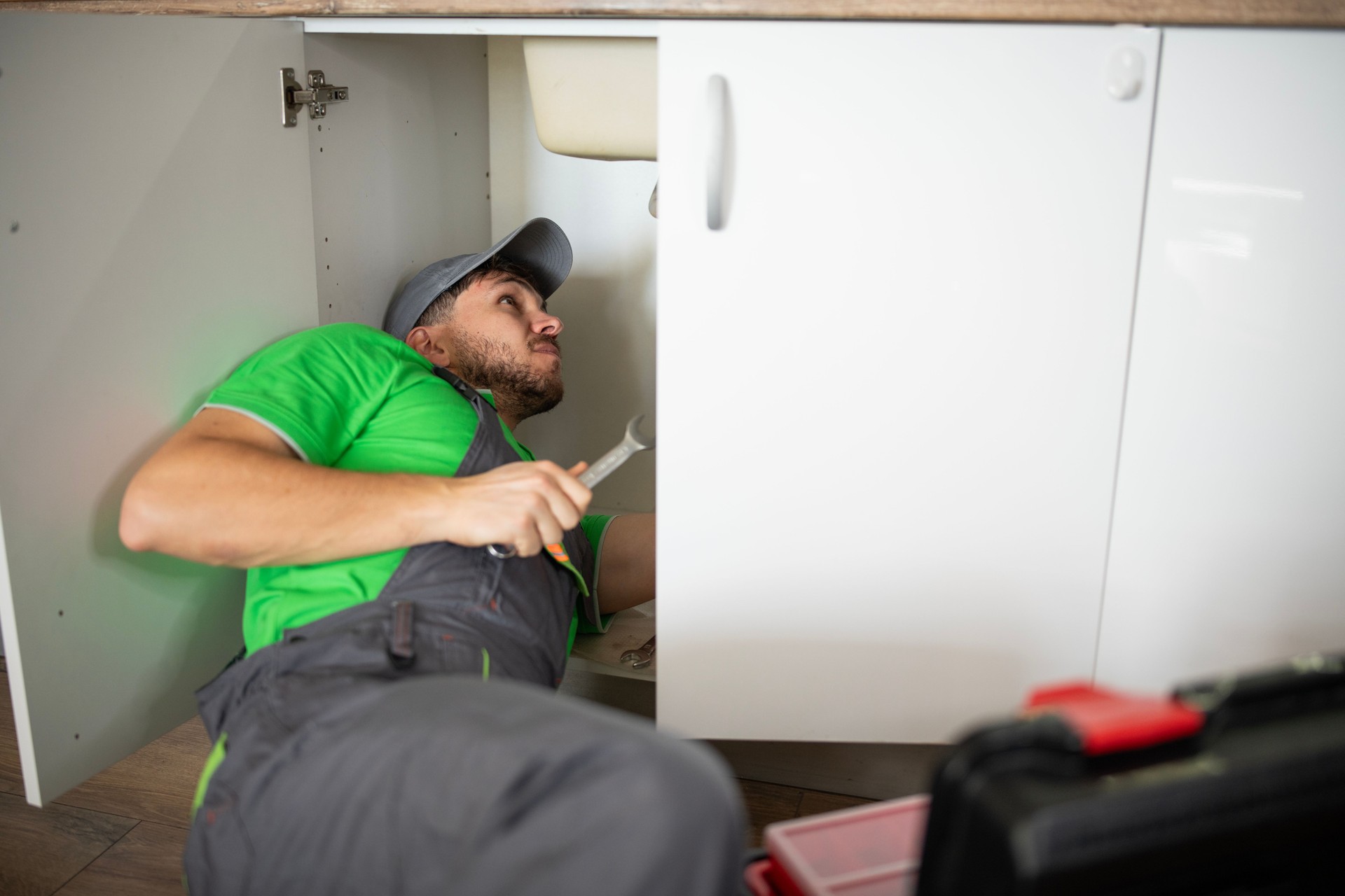 Experienced plumber fixing a clogged kitchen sink in a private home